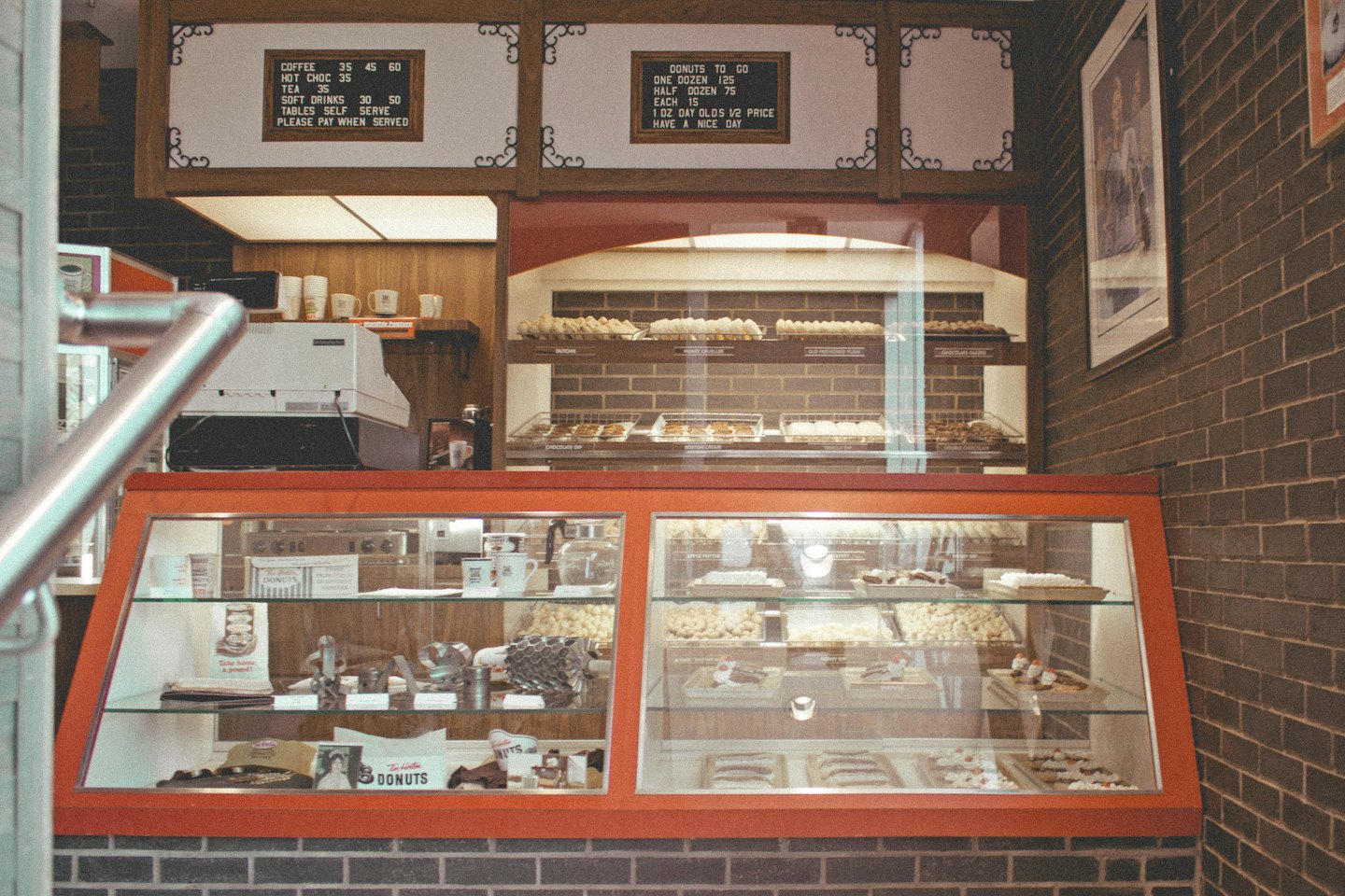 Donuts and drinks displayed inside a retro shop counter.